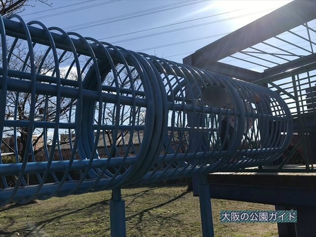 「新町南公園」の大型遊具、輪の中をくぐる様子